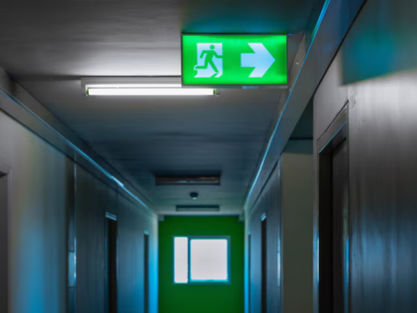 Qual a importância de placas de sinalização de saída de emergência em estabelecimentos comerciais?