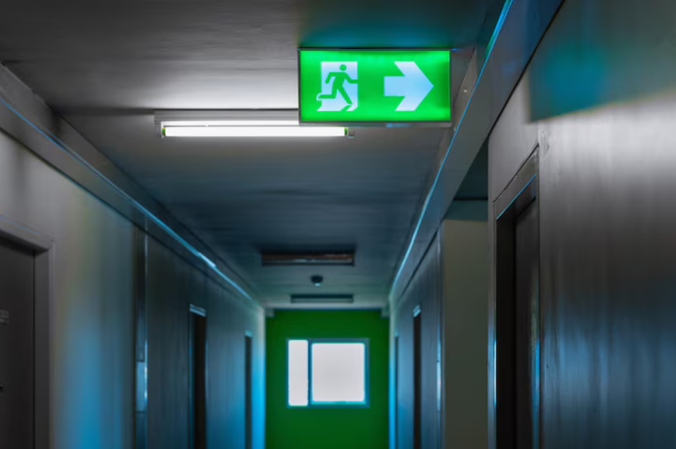 Qual a importância de placas de sinalização de saída de emergência em estabelecimentos comerciais?